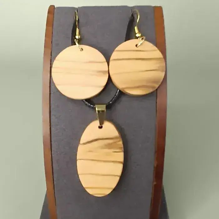 Parure artisanale Éternel Olivier en bois d’olivier sur présentoir.