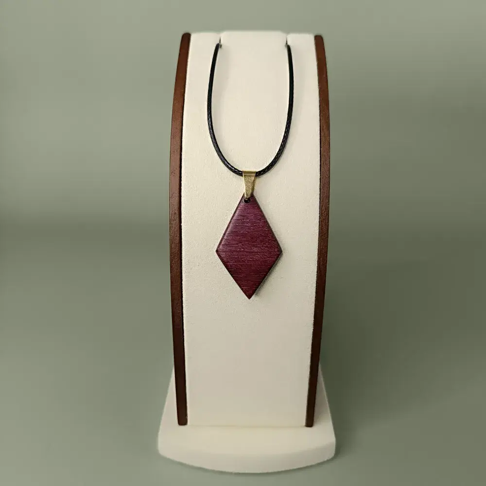 Vue de face du pendentif Reflet Violet en bois d’Amarante losange, veinages violets et brun-rouge.