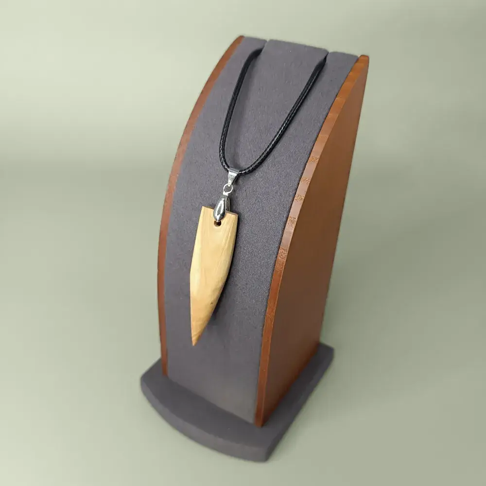 Pendentif en bois artisanal Élan Boisé, vue de côté sur support.