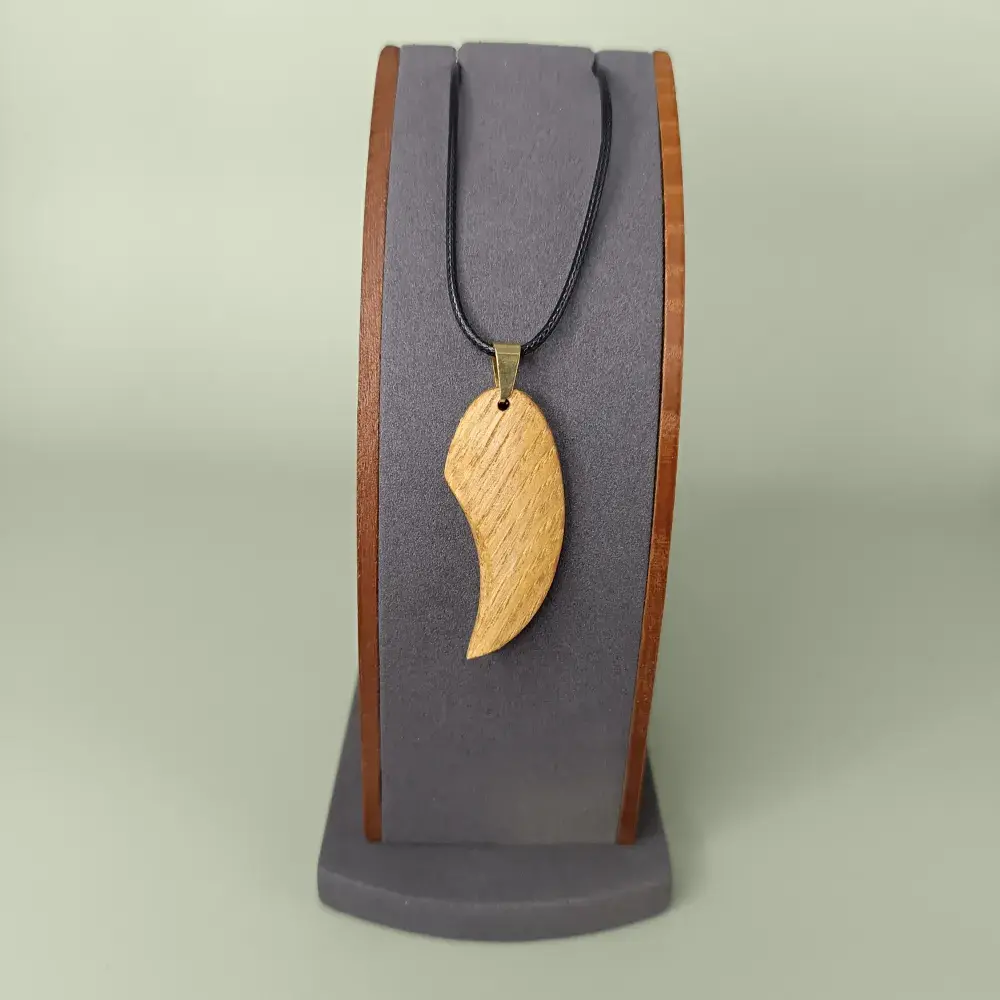 Pendentif design artisanal en bois Élan Courbé vue de face.