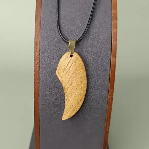 Pendentif en bois fait-main Élan Courbé sur présentoir.
