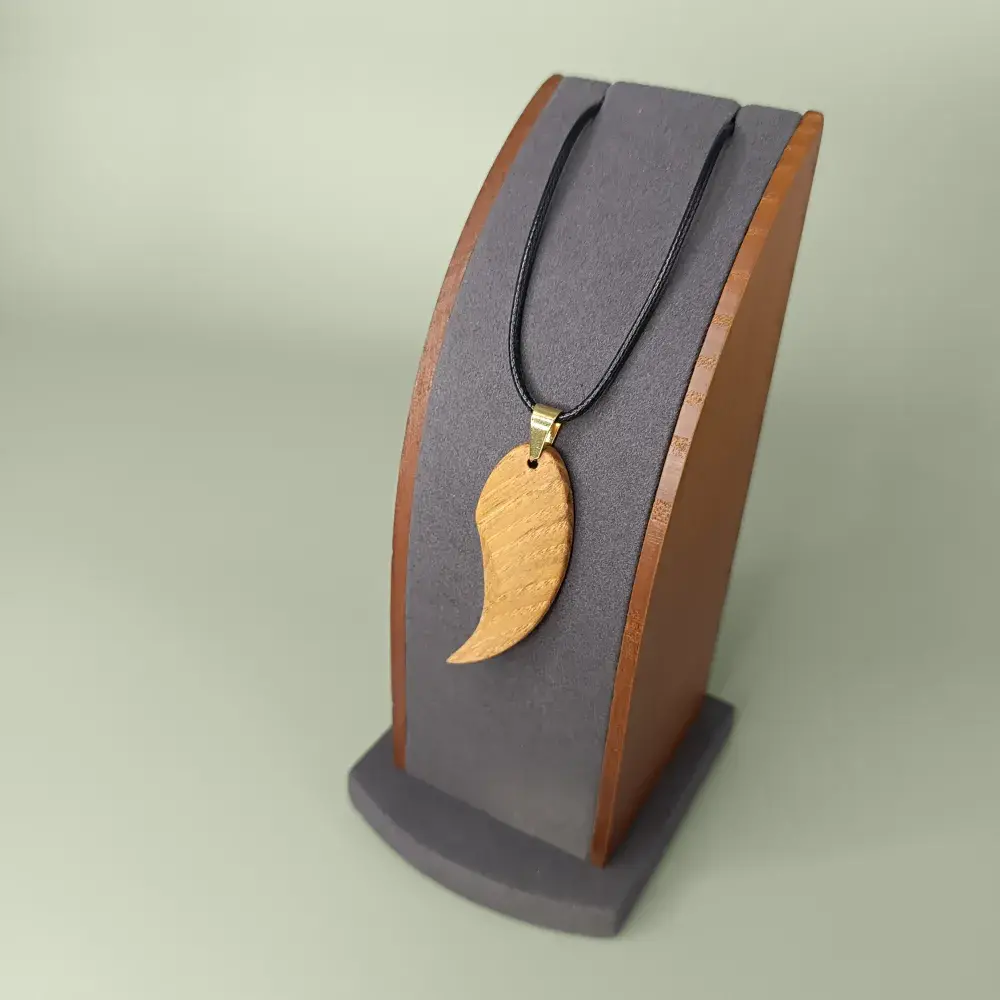 Pendentif bois artisanal sculpté à la main, Skyline Artwood sur présentoir.