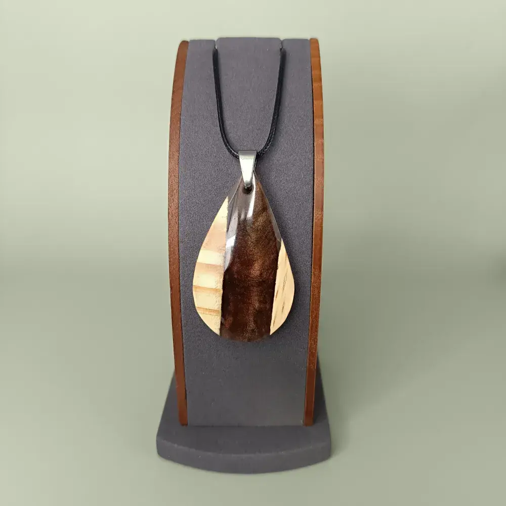 Pendentif en bois de pin et résine marron, vue de face sur présentoir.