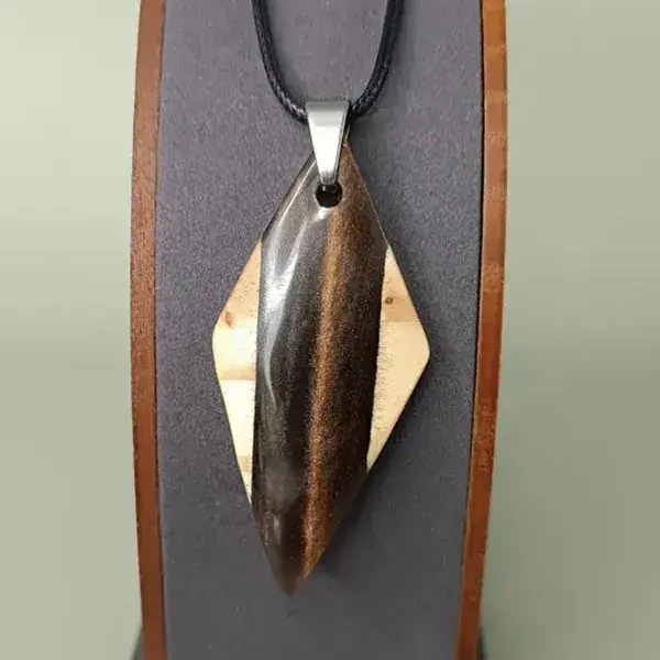 Pendentif losange en bois de pin et résine brun irisé sur présentoir.