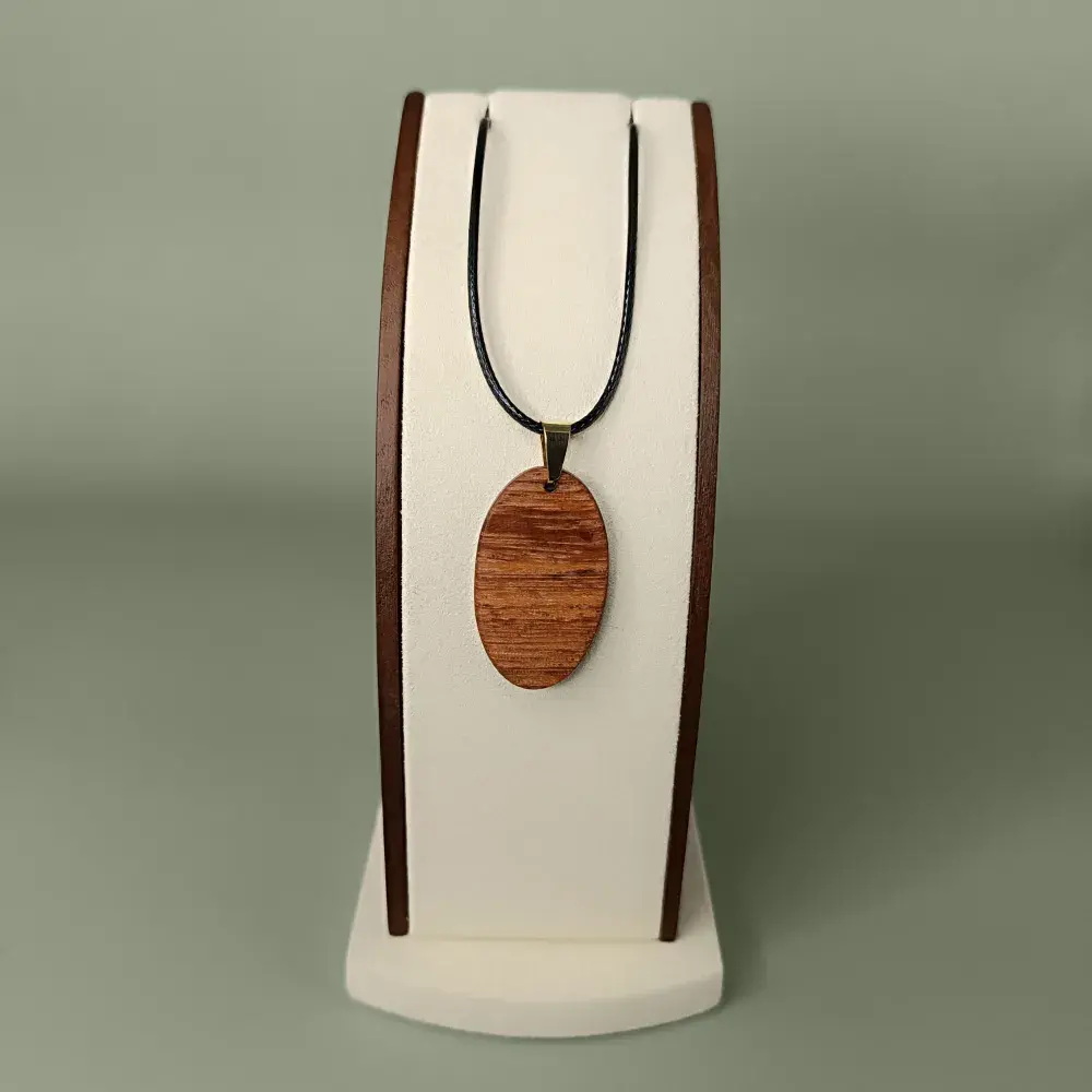 Vue de face du pendentif Rayon Doré en bois de Saint Martin Jaune, forme ovale, veinages miel et dorés subtils.