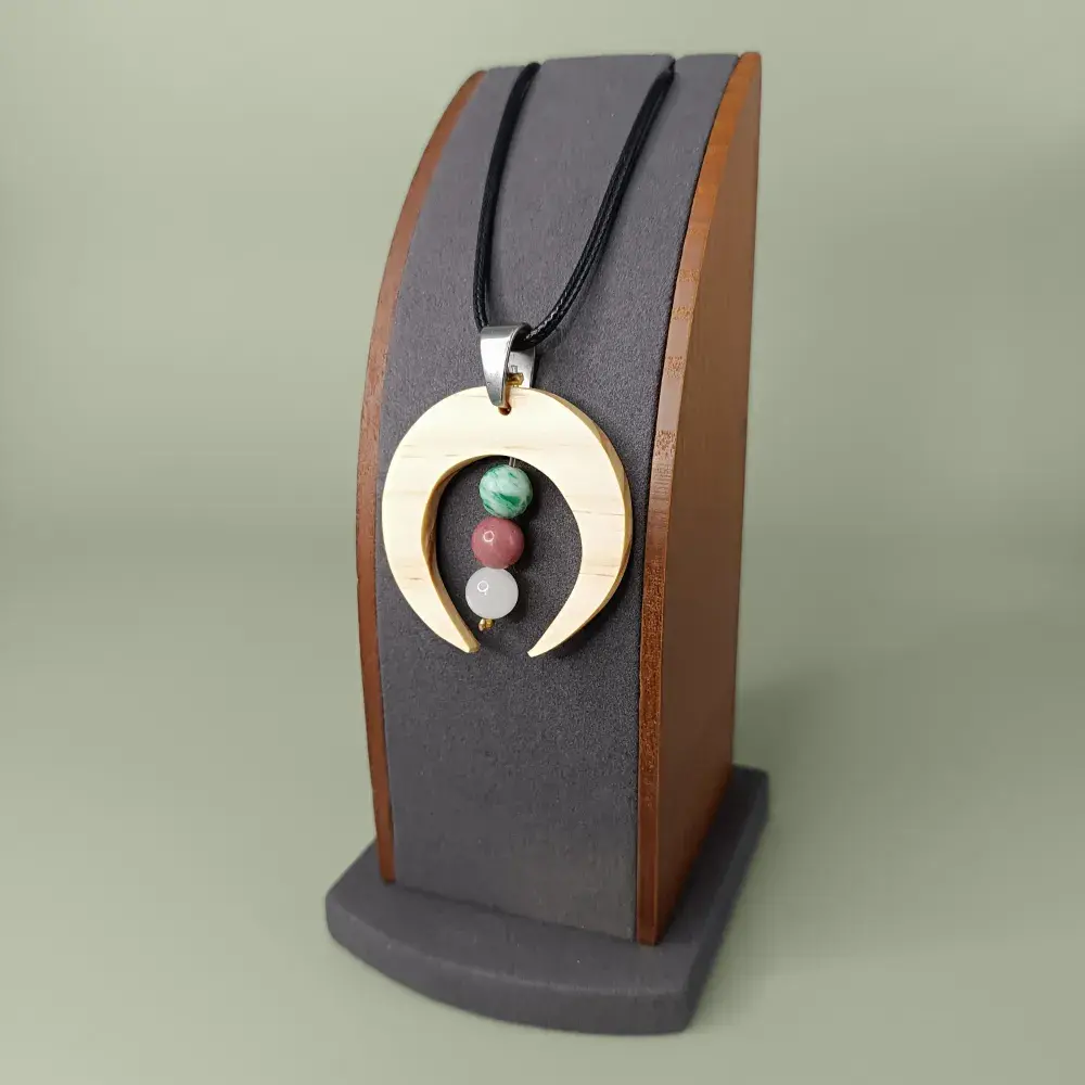 Plan latéral du pendentif en bois naturel avec trois pierres fines, élégant.