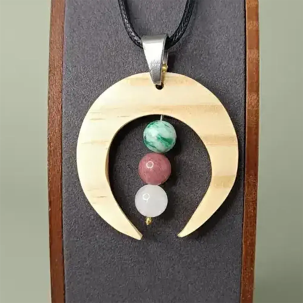 Pendentif en bois naturel avec trois pierres fines et élégant.
