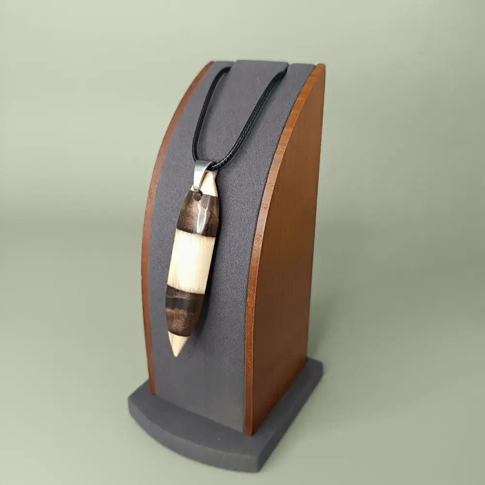 Pendentif en bois de pin et résine marron, vue latérale et plongeante sur présentoir.