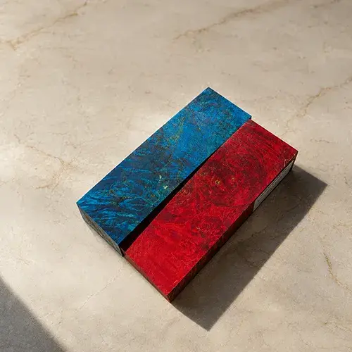 Blocs de loupe de châtaignier stabilisée bleue et rouge avant façonnage.