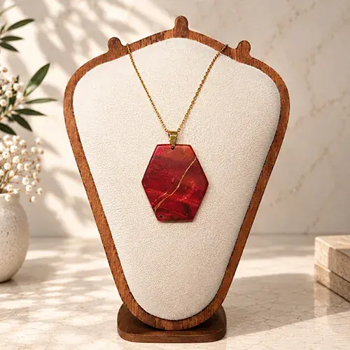 Pendentif artisanal en loupe de châtaignier stabilisée rouge par Skyline Artwood.