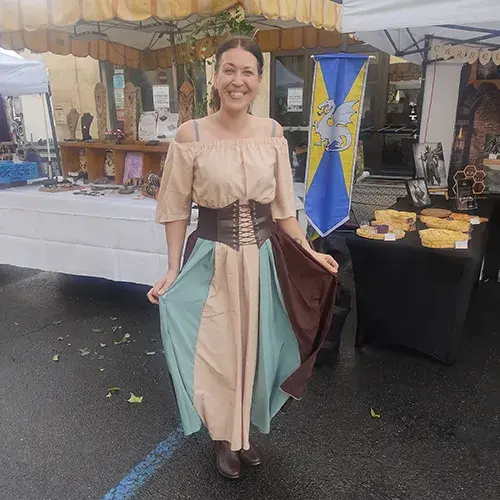 Créatrice de Skyline Artwood – bijoux et objets artisanaux en bois – au marché nocturne médiéval de Charlieu en juillet 2025.